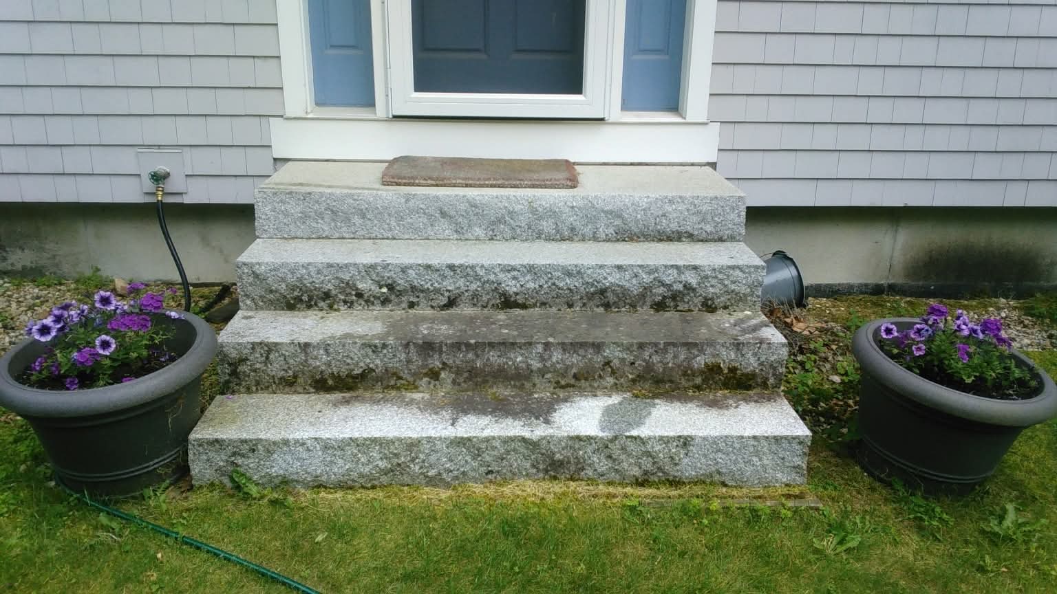 Granite steps before pressure washing in Grantham NH — moss and algae buildup
